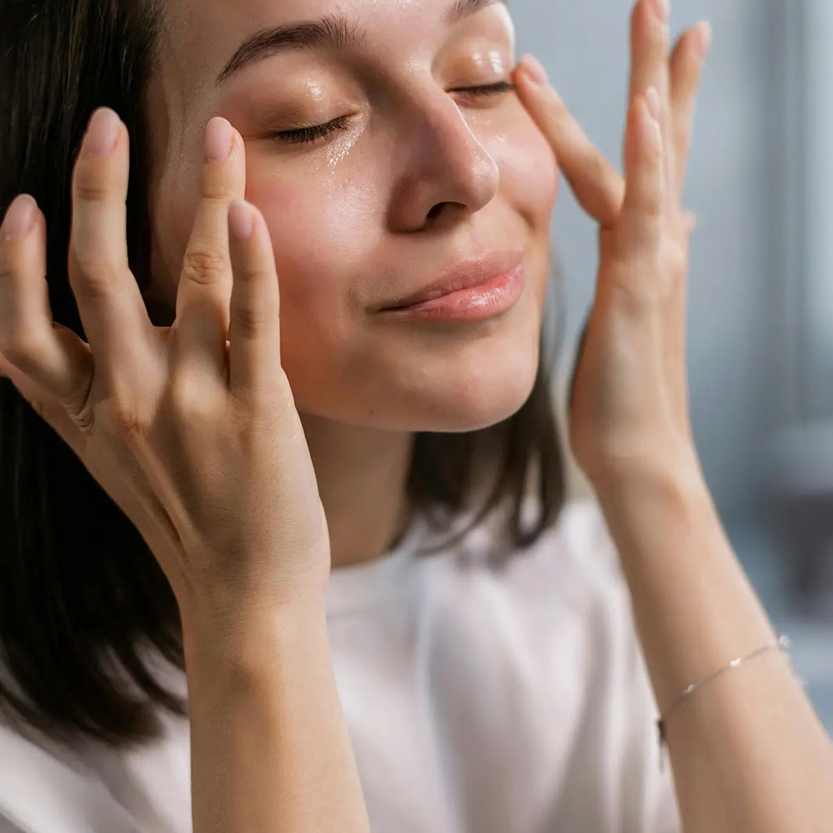 woman applying skincare - for article on  Retinoids, Hyaluronic Acid, and Vitamin C