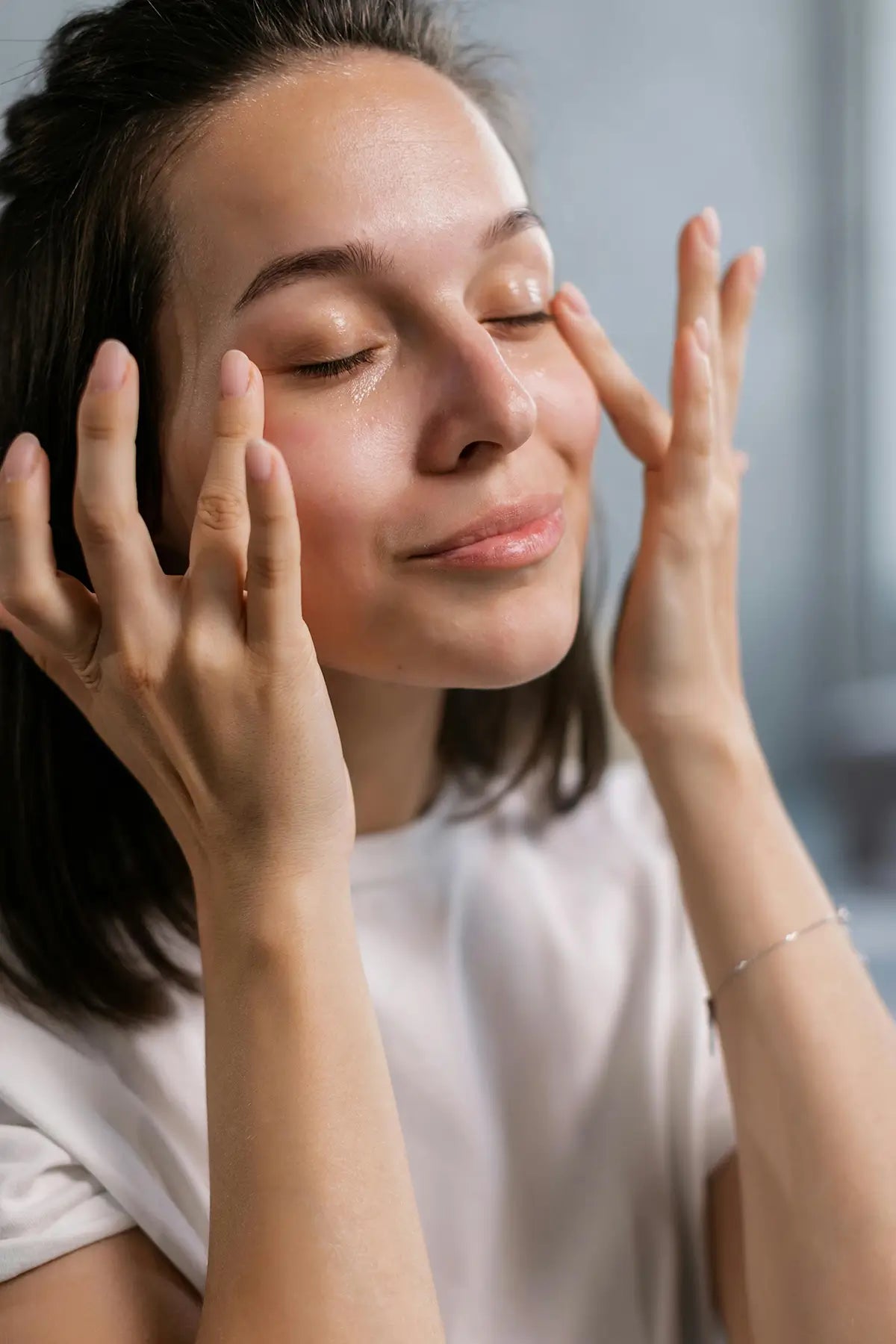 woman applying skincare - for article on  Retinoids, Hyaluronic Acid, and Vitamin C